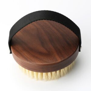 A premium boar bristle brush with a wooden handle, designed to exfoliate and rejuvenate skin for a natural glow.
