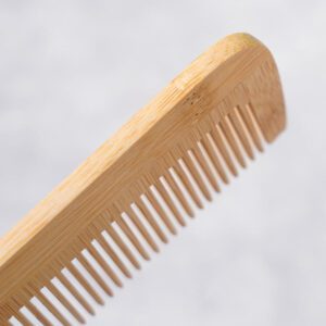 Compact bamboo hair comb with wide teeth and rounded edges, wide tooth wooden comb style for gentle detangling.