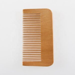 Compact bamboo hair comb with wide teeth and rounded edges, wide tooth wooden comb style for gentle detangling.