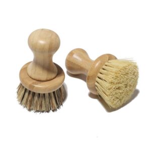 Bamboo-handled round scrubber for kitchen use with natural sisal bristles on a white background