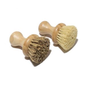 Bamboo-handled round scrubber for kitchen use with natural sisal bristles on a white background