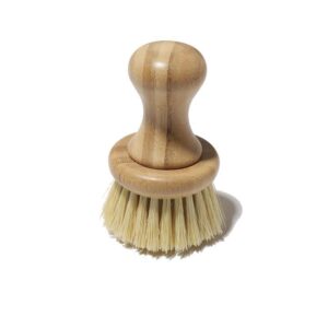 Bamboo-handled round scrubber for kitchen use with natural sisal bristles on a white background