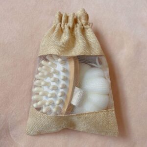 Bath body gift set in a linen tote bag with natural loofah sponges, scrubbing stone for feet, and bath ball.