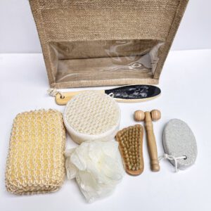 Natural bath and body set with dry body brush, loofah sponges, pumice stone, and more, neatly arranged in a linen handbag.