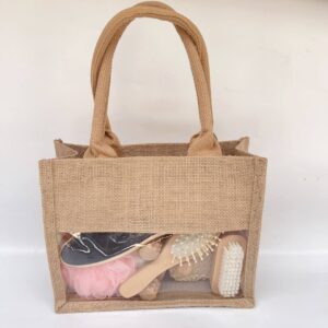 Natural bath and body set with dry body brush, loofah sponges, pumice stone, and more, neatly arranged in a linen handbag.