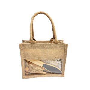Natural bath and body set with dry body brush, loofah sponges, pumice stone, and more, neatly arranged in a linen handbag.