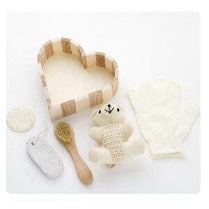 Body care gift set displayed in a wooden bath and body gift box with brush, loofah, pumice stone, towel, and teddy bear decoration.