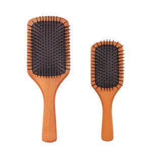 Detangling brush for hair with rubber cushion base and wooden handle, designed for scalp massage and smooth brushing.