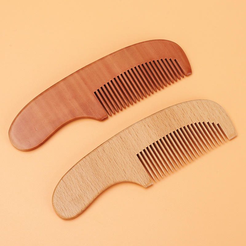 Small wooden baby comb with rounded handle and smooth teeth, portable travel use design for gentle daily grooming.