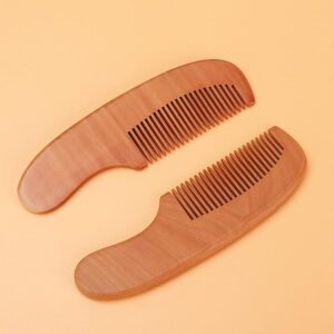 Small wooden baby comb with rounded handle and smooth teeth, portable travel use design for gentle daily grooming.