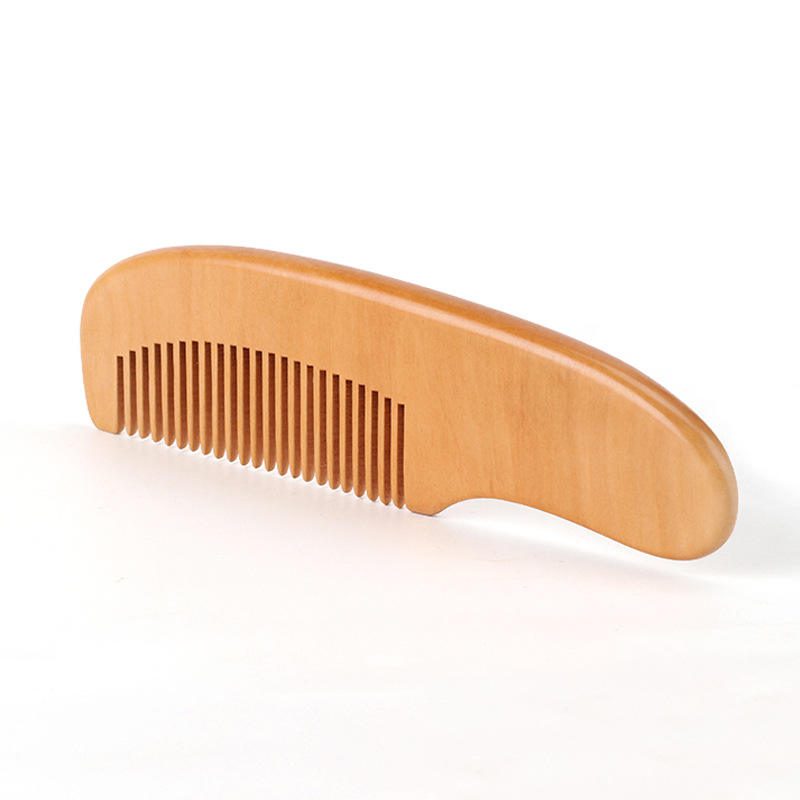 Small wooden baby comb with rounded handle and smooth teeth, portable travel use design for gentle daily grooming.