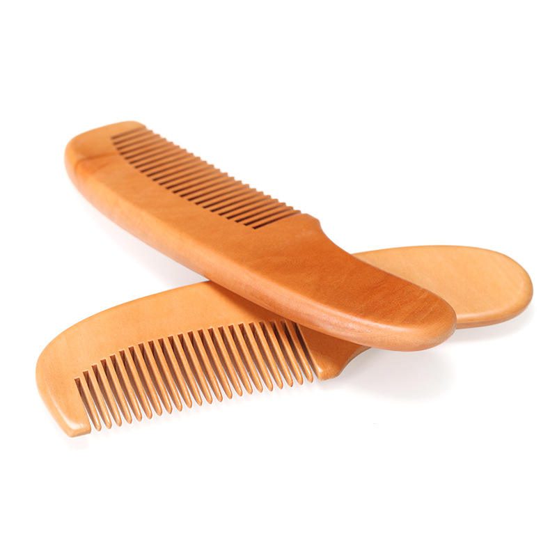 Small wooden baby comb with rounded handle and smooth teeth, portable travel use design for gentle daily grooming.