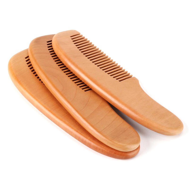 Small wooden baby comb with rounded handle and smooth teeth, portable travel use design for gentle daily grooming.