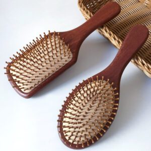 Wooden hair growth comb with rounded massage pins, designed to stimulate the scalp and support healthy brushing routines.