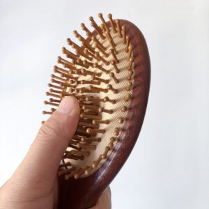 Wooden hair growth comb with rounded massage pins, designed to stimulate the scalp and support healthy brushing routines.