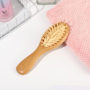 Scalp massage comb with beech wood handle and cushioned pins, designed for gentle detangling and daily hair care