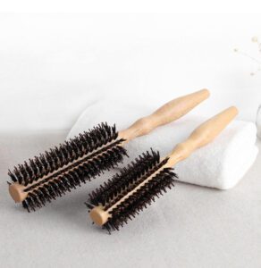 Small round hairbrush with wooden handle and mixed bristles, a wooden hairbrush designed as a round hair brush for styling.