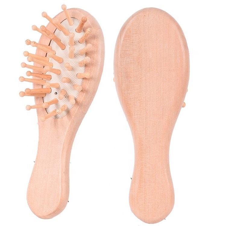 Small wooden hair brush for children with airbag cushion and rounded massage pins.