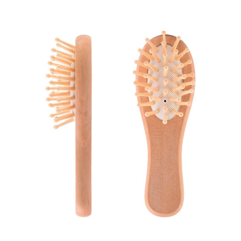 Small wooden hair brush for children with airbag cushion and rounded massage pins.