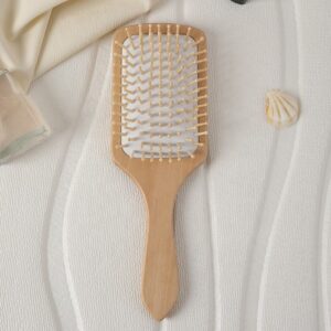 Massage comb with wooden handle and wood bristles, designed for scalp stimulation and daily hair care use.