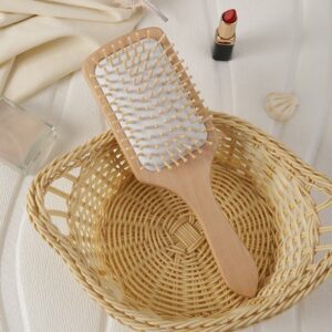 Massage comb with wooden handle and wood bristles, designed for scalp stimulation and daily hair care use.