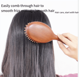 Round wooden hair brush made of sandalwood with air cushion and smooth pins for gentle scalp massage.