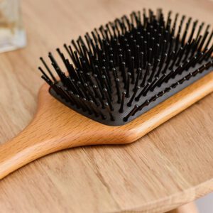Wooden comb with rubber cushion base, designed as a comb massager for daily hair brushing.