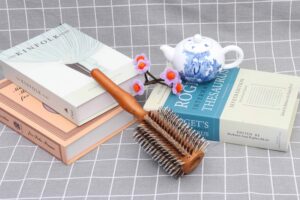 Wooden round hair brush with boar bristles for smooth styling, curling, and detangling.