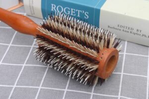 Wooden round hair brush with boar bristles for smooth styling, curling, and detangling.