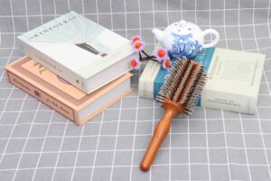 Wooden round hair brush with boar bristles for smooth styling, curling, and detangling.