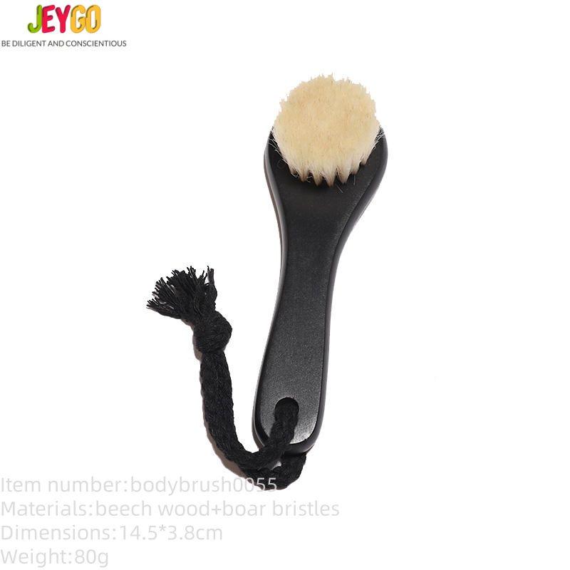 Black body dry brush with soft goat hair bristles and compact handle, designed for gentle exfoliation.