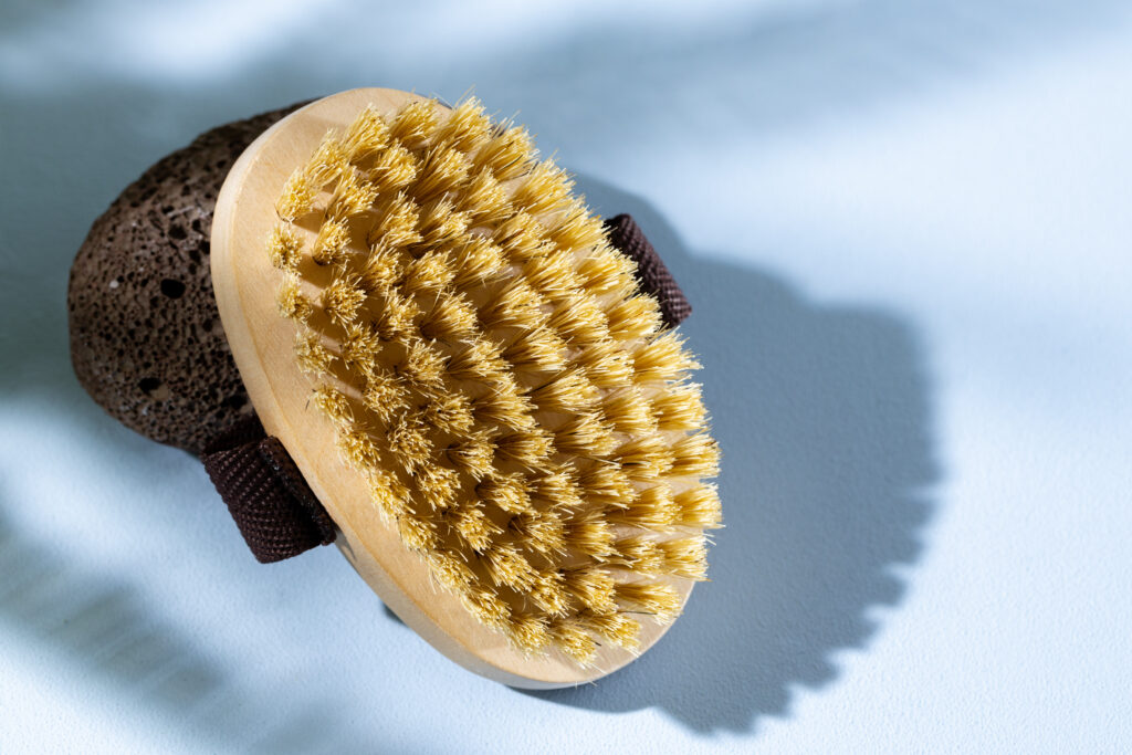 A dry body brush with natural bristles, designed for exfoliating and massaging the skin for a smoother, healthier appearance.