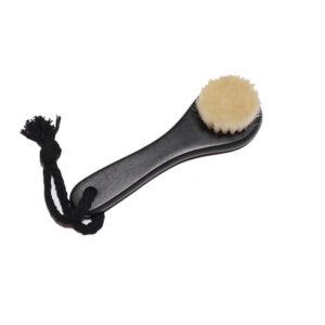 Black body dry brush with soft goat hair bristles and compact handle, designed for gentle exfoliation.