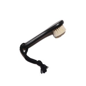 Black body dry brush with soft goat hair bristles and compact handle, designed for gentle exfoliation.