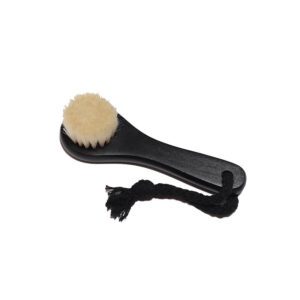 Black body dry brush with soft goat hair bristles and compact handle, designed for gentle exfoliation.