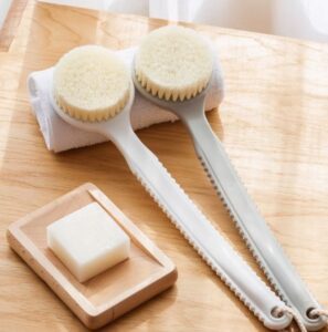 Plastic body massage brush with soft bristles, perfect for gentle exfoliation and dry brushing for sensitive skin.