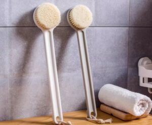 Plastic body massage brush with soft bristles, perfect for gentle exfoliation and dry brushing for sensitive skin.