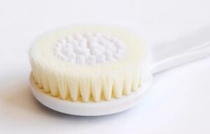 Plastic body massage brush with soft bristles, perfect for gentle exfoliation and dry brushing for sensitive skin.