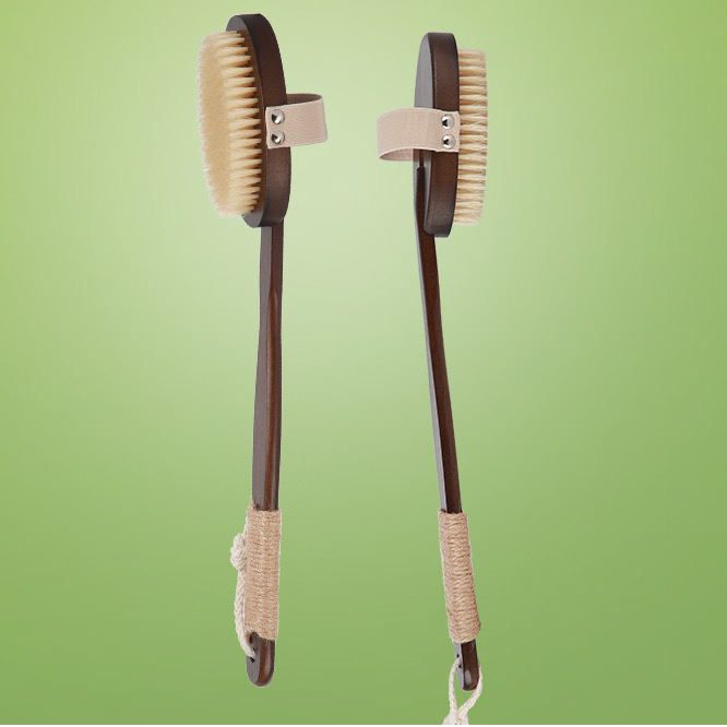 Natural bristle scrub brush with dark bamboo handle, featuring soft bristles and a strap for exfoliating and full-body cleansing.