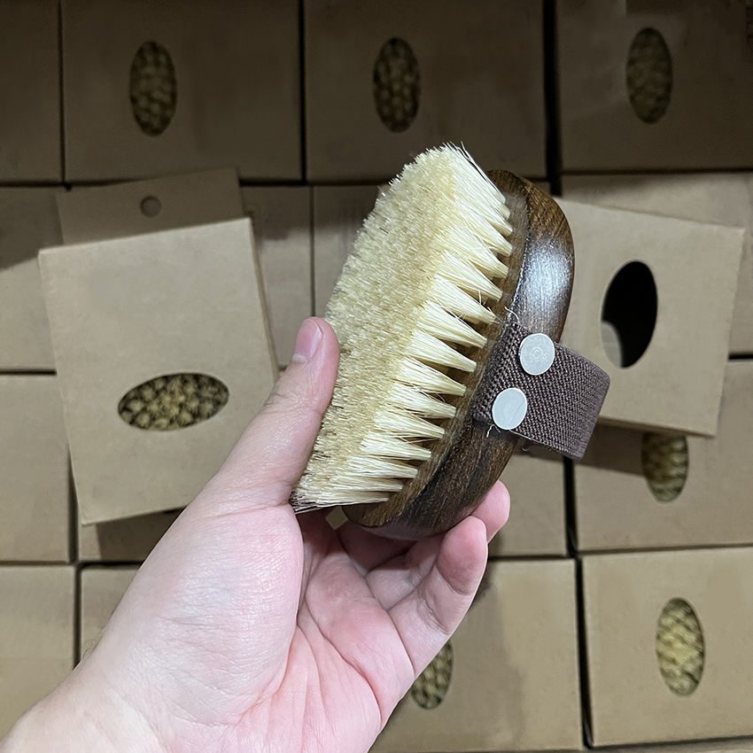 Wooden massage brush with boar bristle and hand strap, suitable for wet and dry use as a shower brush.