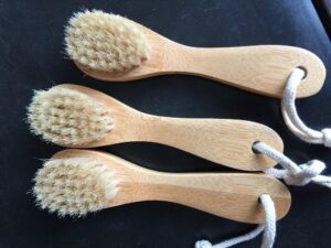 Wooden bath brush with natural bristles and ergonomic handle, designed as an exfoliating shower scrubber.