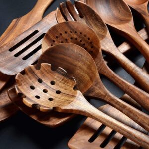 Twelve-piece set of natural teak wooden kitchen utensils including spatulas, slotted spoons, soup spoons, serving utensils, and stirring tools, designed for cooking and serving