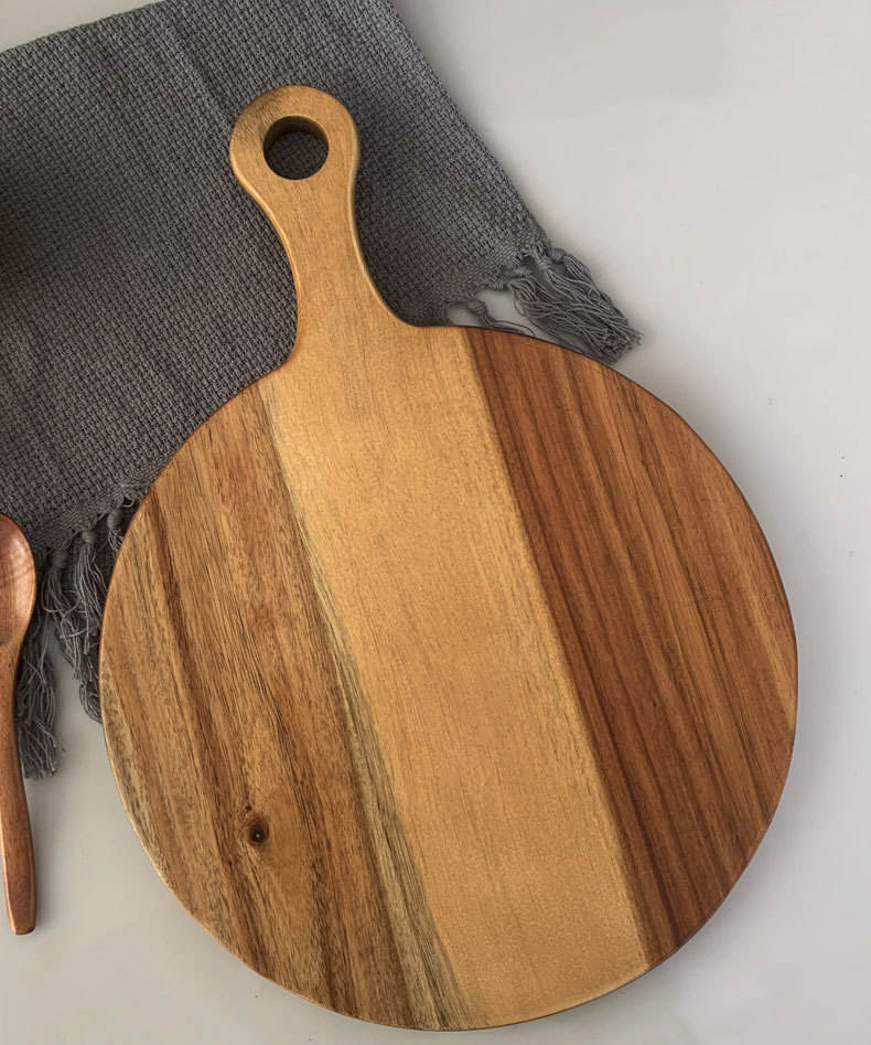 Round acacia wood cutting board featuring a handle, ideal for serving fruit, sushi, pizza, and steak, suitable for home kitchens and professional settings