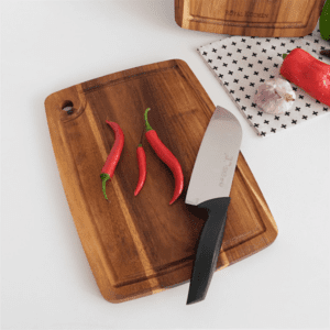 Rectangular acacia wood cutting board with built-in juice groove and hanging hole, ideal for chopping fruits, vegetables, and meats, suitable for kitchen use and serving