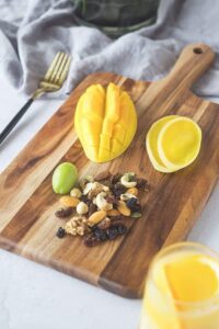 acacia wood cutting board with handle for pizza serving, cheese presentation, bread display and food preparation
