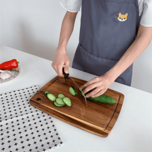 Rectangular acacia wood cutting board with built-in juice groove and hanging hole, ideal for chopping fruits, vegetables, and meats, suitable for kitchen use and serving