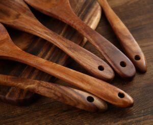 Seven-piece acacia wood cooking utensil set including spatulas, serving spoons, pasta server, slotted spoon, and cooking tools designed for non-stick cookware and kitchen use