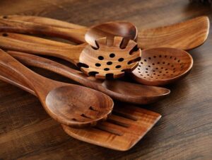 Seven-piece acacia wood cooking utensil set including spatulas, serving spoons, pasta server, slotted spoon, and cooking tools designed for non-stick cookware and kitchen use