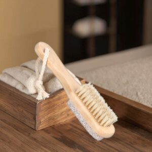 Wooden foot scrubber featuring natural boar bristles and pumice stone for exfoliating dead skin, cleaning feet, and removing callusesThis double-sided pumice stone foot scrubber is designed to provide a complete foot care experience by combining gentle cleansing and effective exfoliation in one convenient tool. One side features natural boar bristles that help remove dirt, refresh the skin, and stimulate circulation, while the pumice stone side works to reduce calluses, rough patches, and dry skin buildup. The smooth wooden handle offers a comfortable grip and precise control during use, making it suitable for both home pedicures and professional salon treatments. Lightweight and easy to store, the integrated hanging cord allows for quick drying and convenient organization. Ideal for maintaining soft heels and healthy-looking feet, this foot care file is widely used in spas, beauty salons, wellness centers, and personal grooming routines. JEYGO provides wholesale foot file manufacturing with OEM and ODM services, custom logo branding, private label packaging, and factory-direct pricing. A practical choice for beauty distributors, foot care brands, and retailers seeking durable and eco-friendly pedicure accessories.