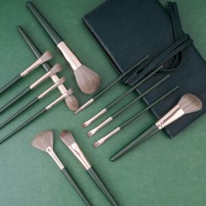 14-piece luxury makeup brush set featuring dark green wood handles, soft synthetic bristles, and professional face and eye brushes for foundation, concealer, powder, blush, and eyeshadow application.